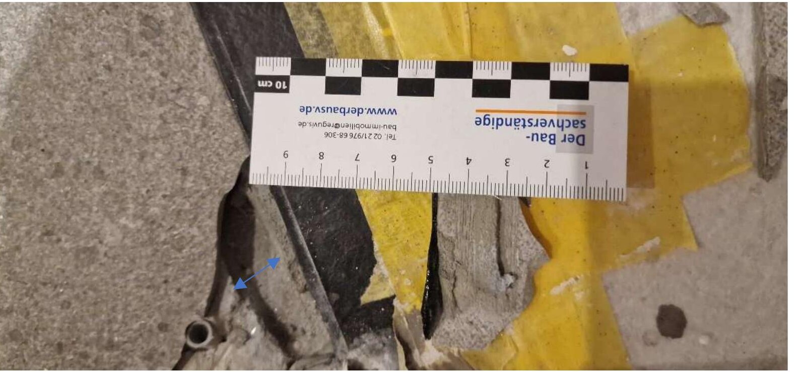 Bauteilöffnung am Fliesenbelag: Kleberbett mit unverdrückter Verzahnung nach Entfernen der lockeren Fliese, Messlatte im Bild